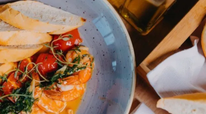 Danie z owocami morza podane w restauracji hotelowej z dodatkiem świeżego pieczywa