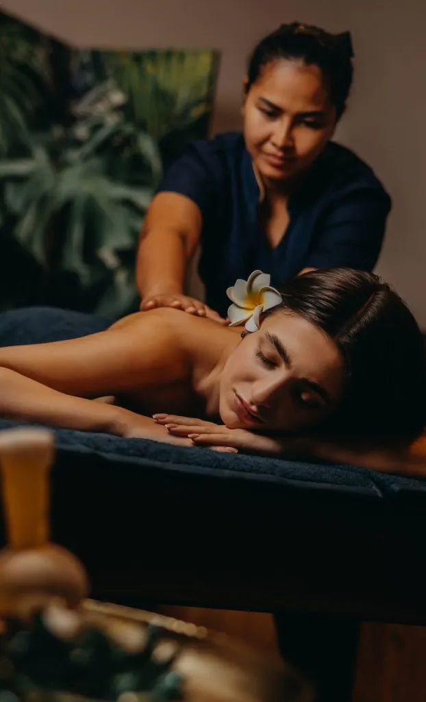 Masaż relaksacyjny w spa, kobieta leżąca na łóżku, aromatyczne świece i spokojna atmosfera wellness