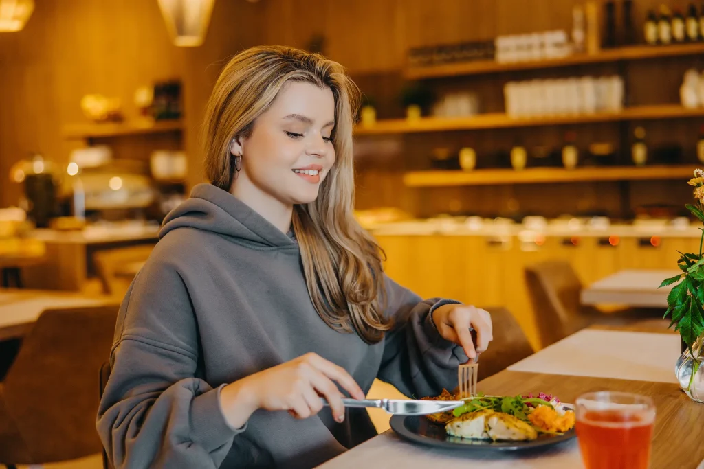 Gość hotelowy delektujący się posiłkiem w restauracji, komfortowa atmosfera i wysoka jakość obsługi