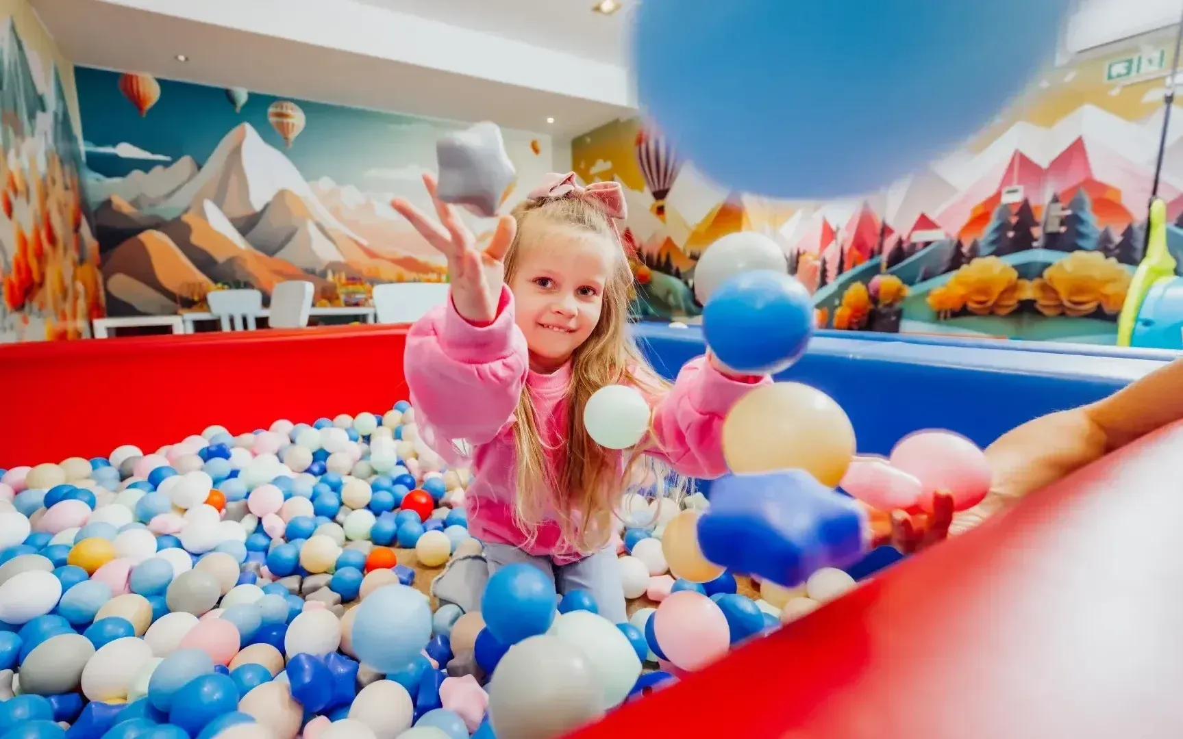 Dítě si hraje v bazénku s míčky