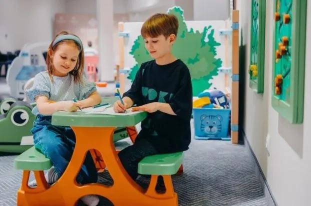Kinder spielen am Tisch im Spielbereich
