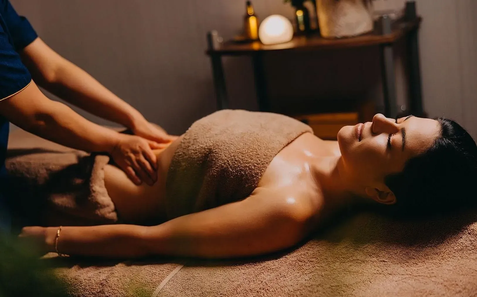 Relaxační masáž v hotelovém spa s atmosférickým osvětlením